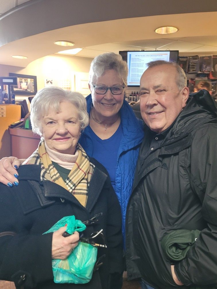 Three people are posing for a picture in a restaurant.