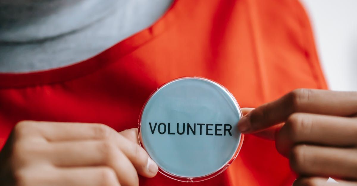 A person is holding a volunteer badge in their hands.