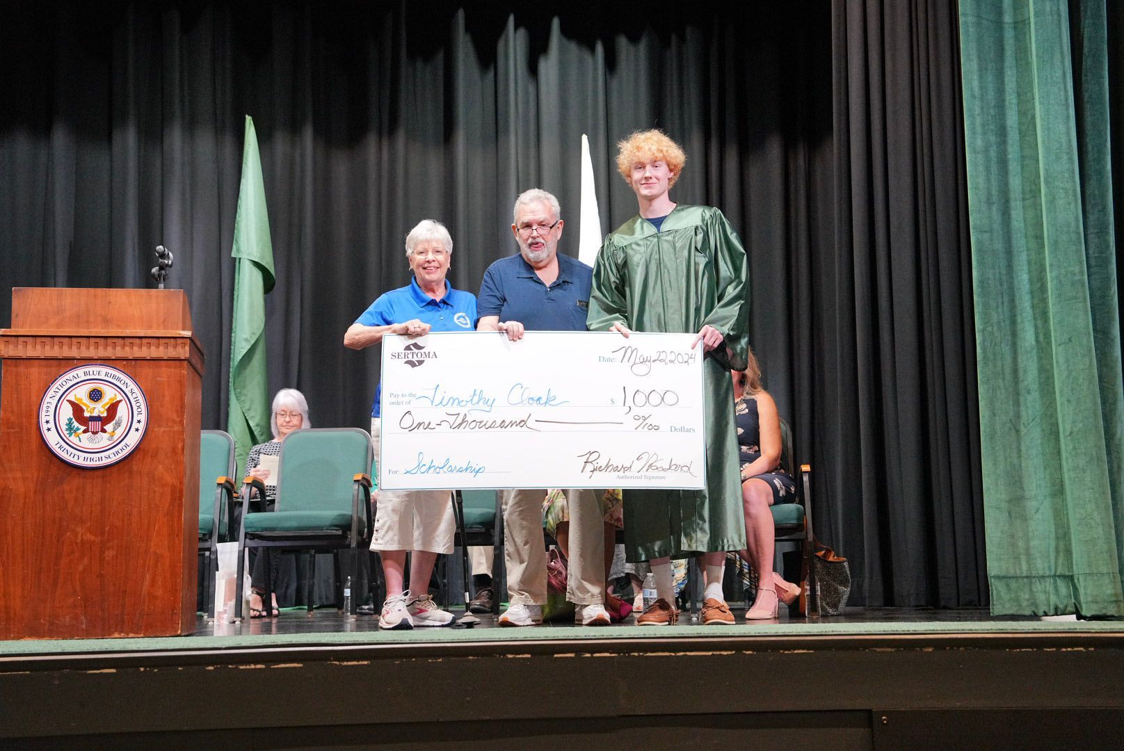 A group of people standing on a stage holding a large check.