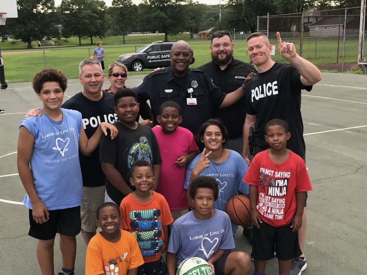 A group of children are posing for a picture with police officers