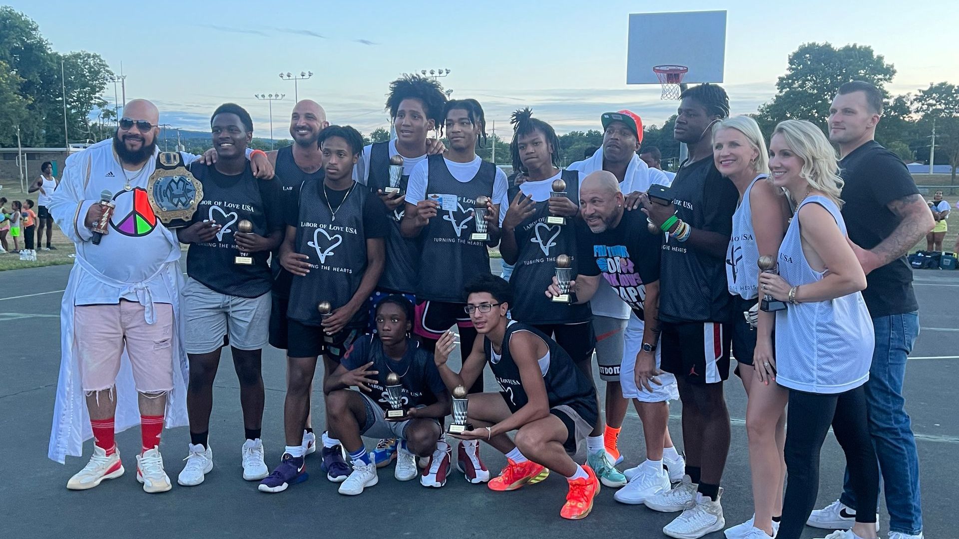 A group of people are posing for a picture on a basketball court.