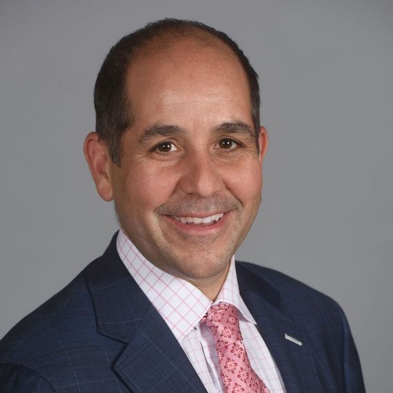 A man and a woman are sitting on a dock overlooking a lake.