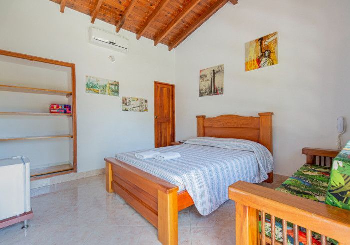 Un dormitorio con una cama de madera y un techo de madera.