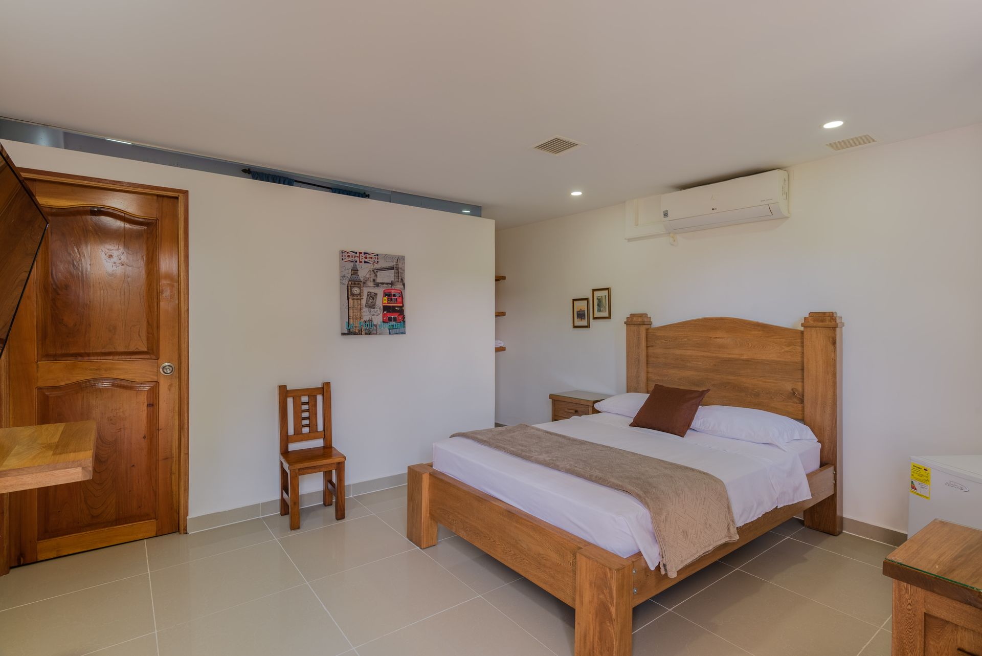 Un dormitorio con una cama grande y una silla.