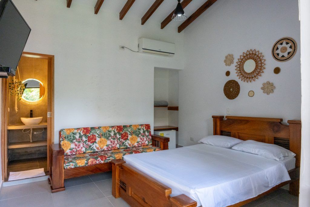 Un dormitorio con cama, sofá y televisión.