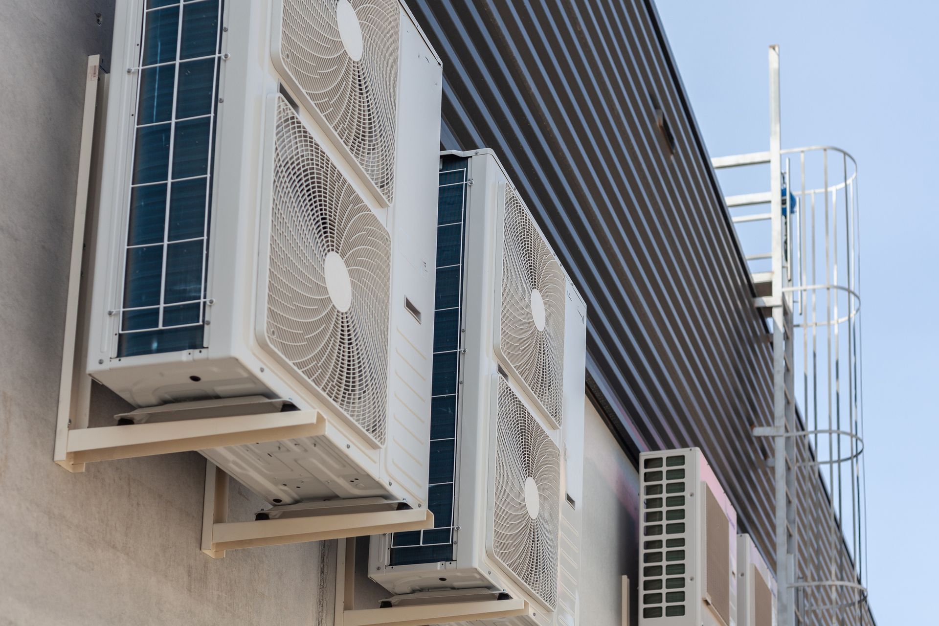A row of air conditioners on the side of a building
