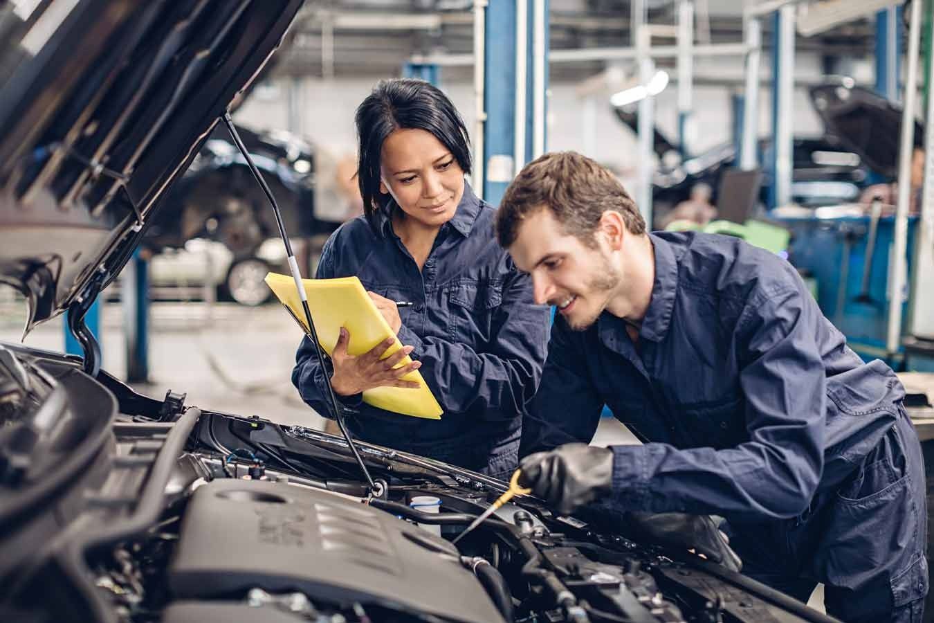 A Man and a Woman Are Working on a Car in a Garage — C L Dickinson Auto Electrics In Narrabri, NSW