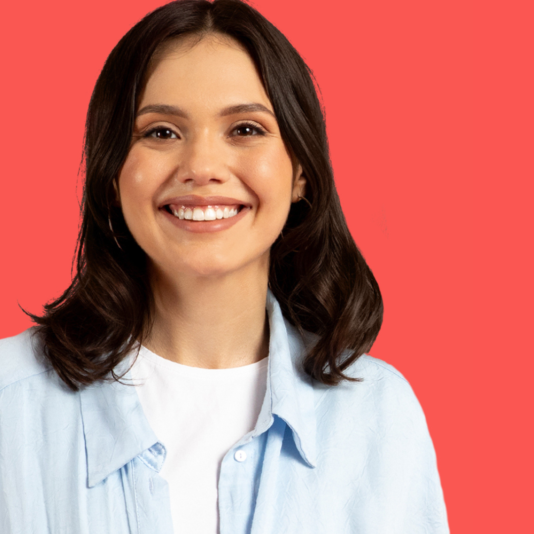 A woman wearing a white shirt and a blue shirt is smiling