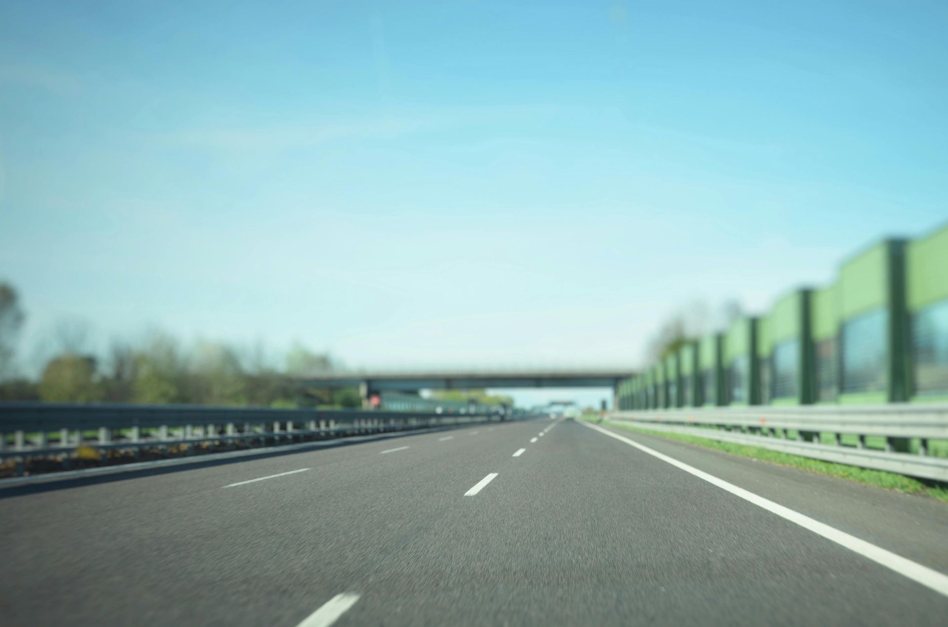 A blurry picture of a highway with a bridge in the background.