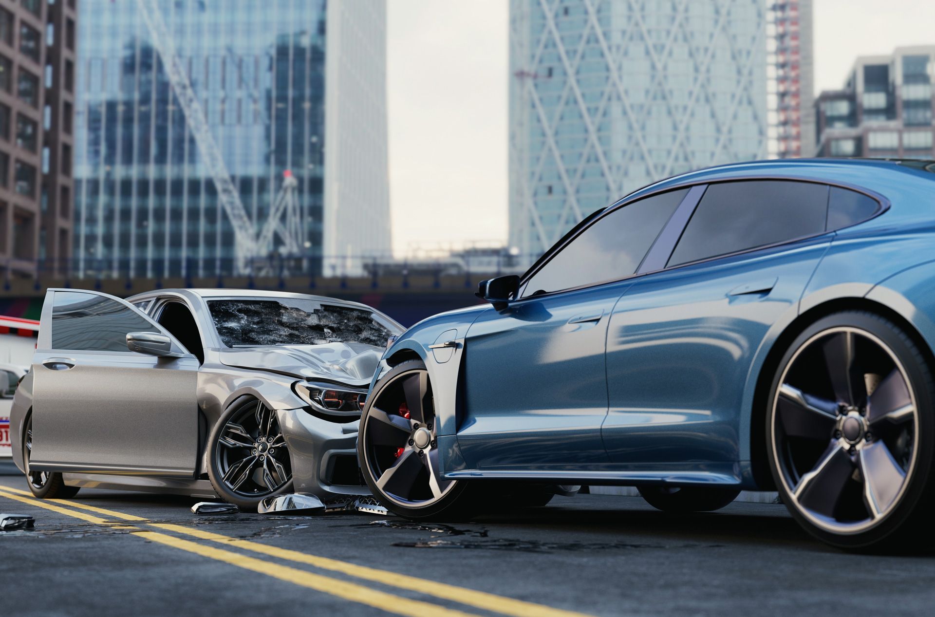 Two cars, a damaged silver car and a blue car, on a city street after a collision.