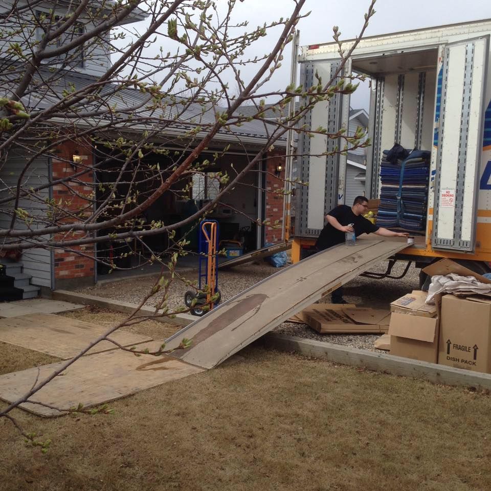 A man is loading boxes into a moving truck