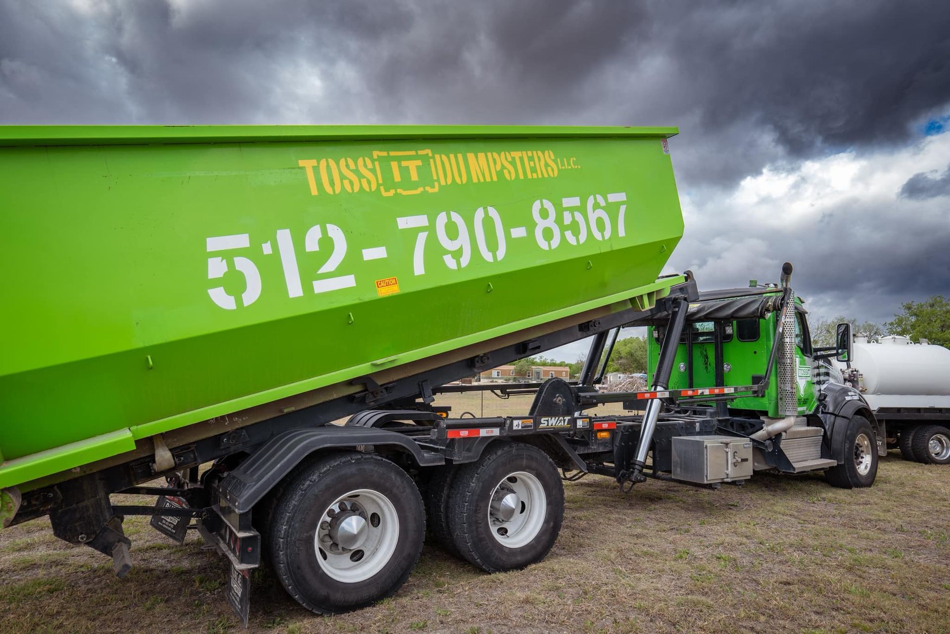 Toss It Dumpster unloading a dumpster rental