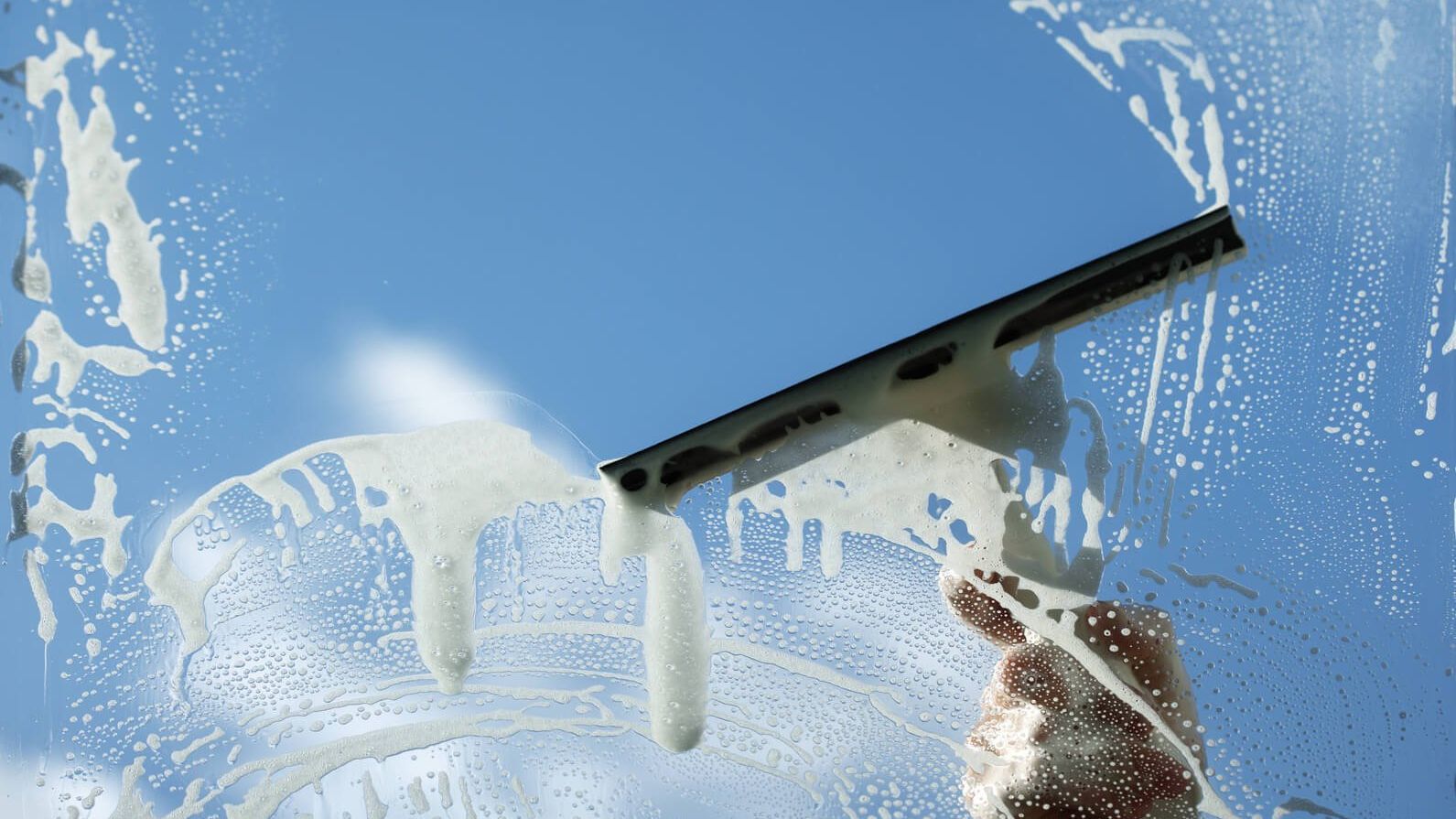 A person is cleaning a window with a squeegee