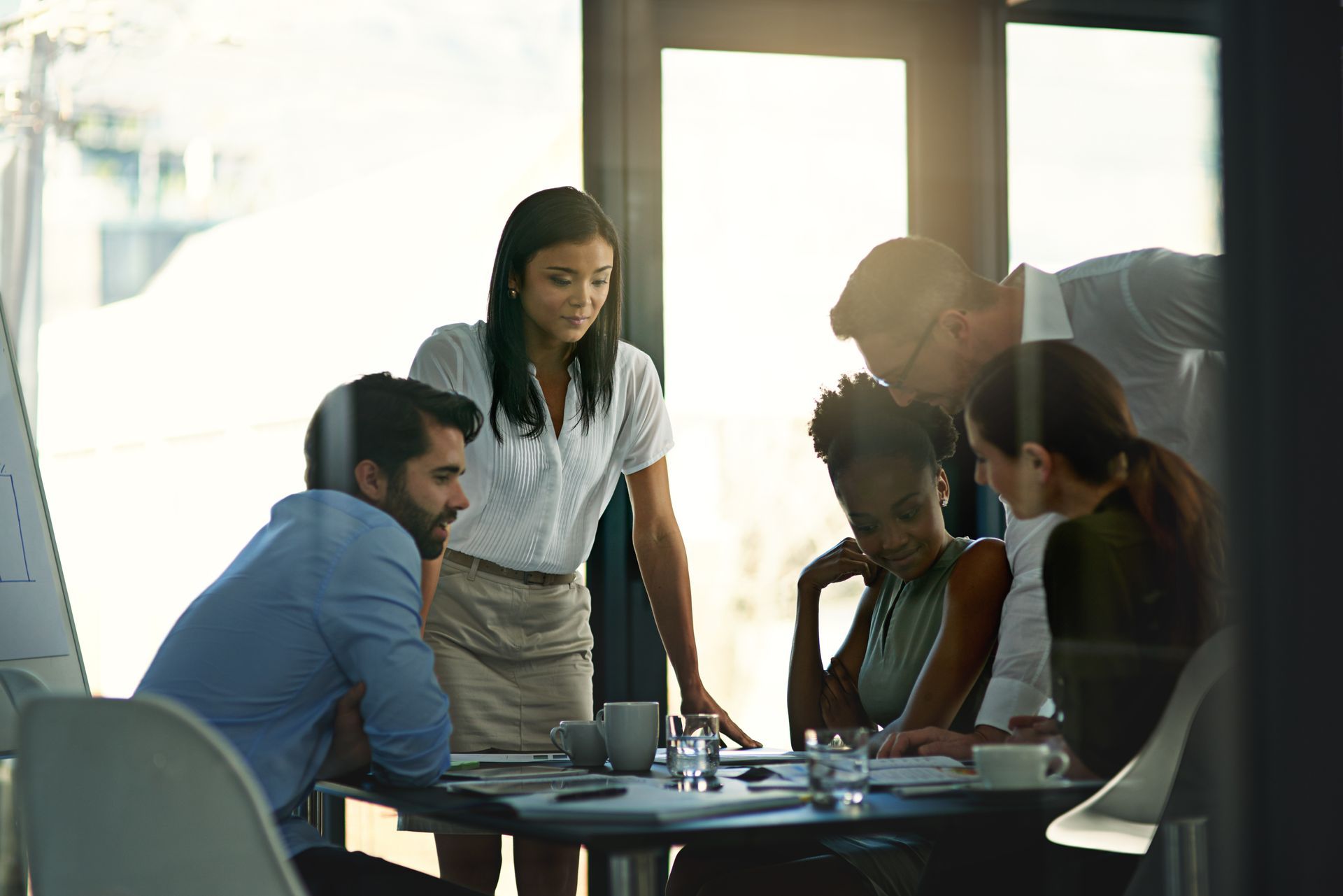 A group of people are sitting around a table having a meeting.