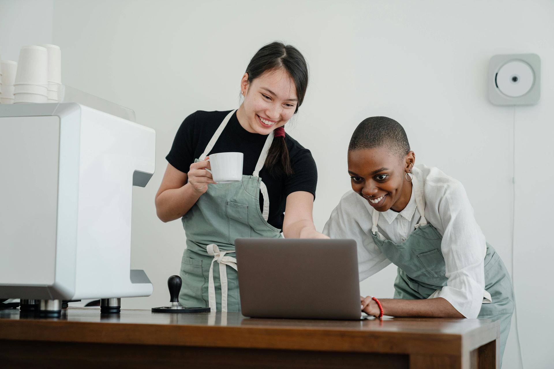 A man and a woman are looking at a laptop computer.
