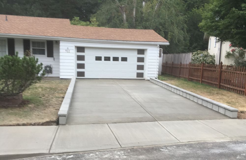 White house with attached garage and concrete driveway.