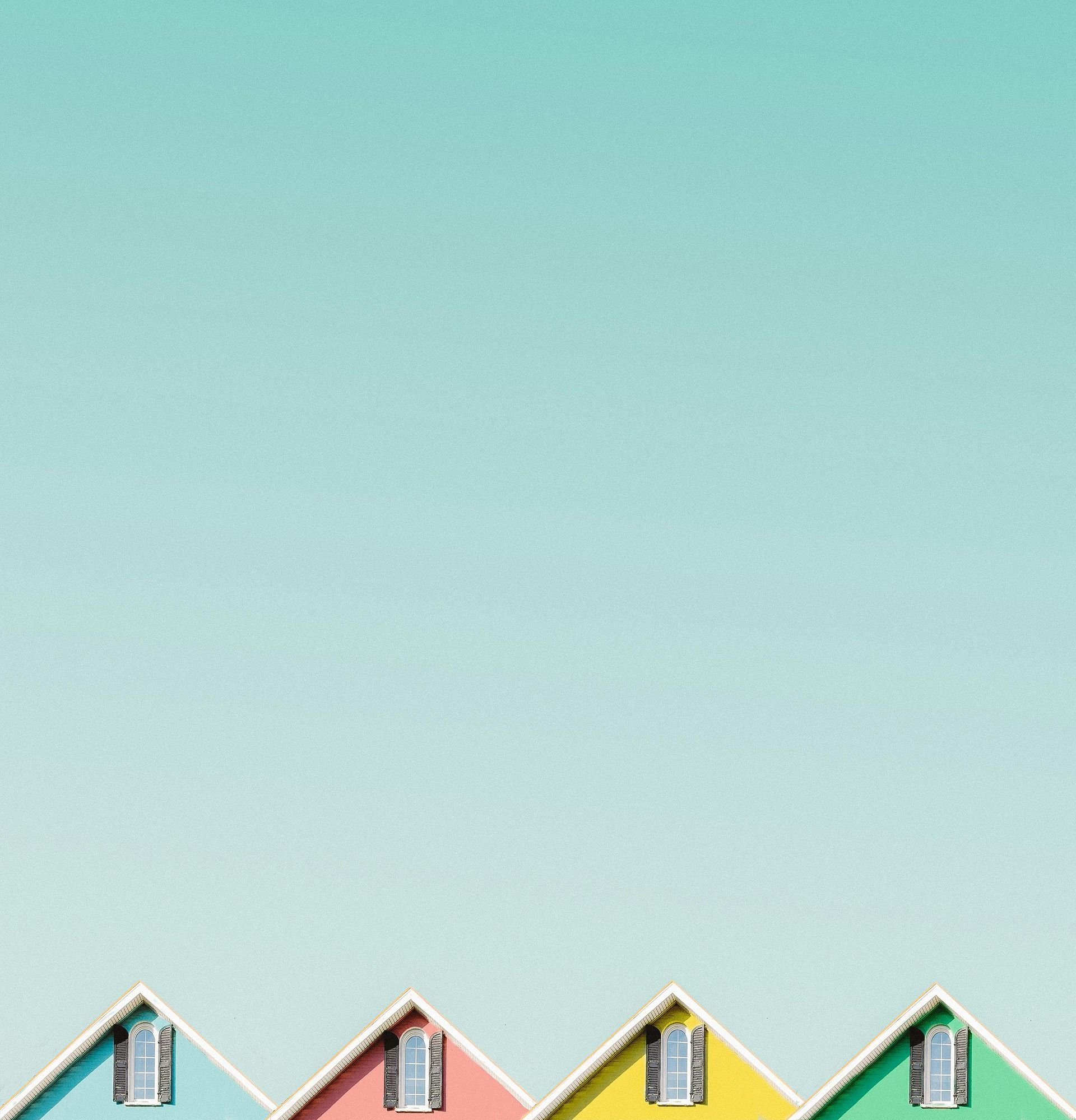 Row of colorful house rooftops against a turquoise sky.