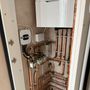 Copper pipes are connected to a white box in a room.