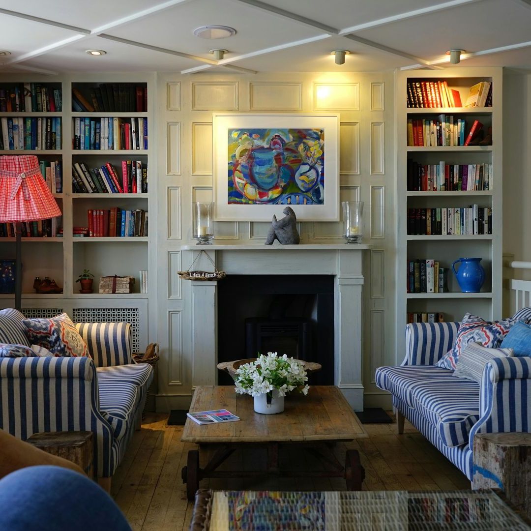 A living room with a fireplace and a painting on the wall
