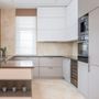 A kitchen with white cabinets and black appliances
