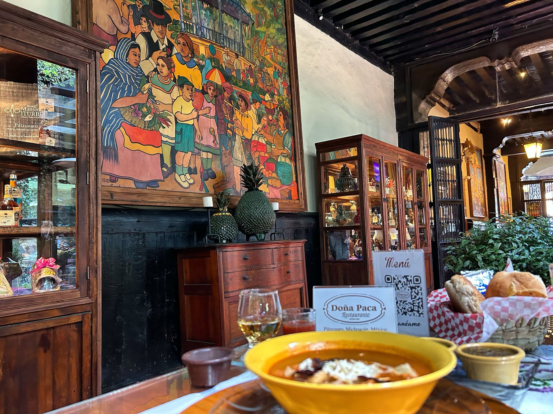 View from a balcony overlooking a plaza with trees, grass, and people in the background.