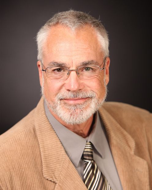 Fleetis Miller with a beard wearing glasses and a tie