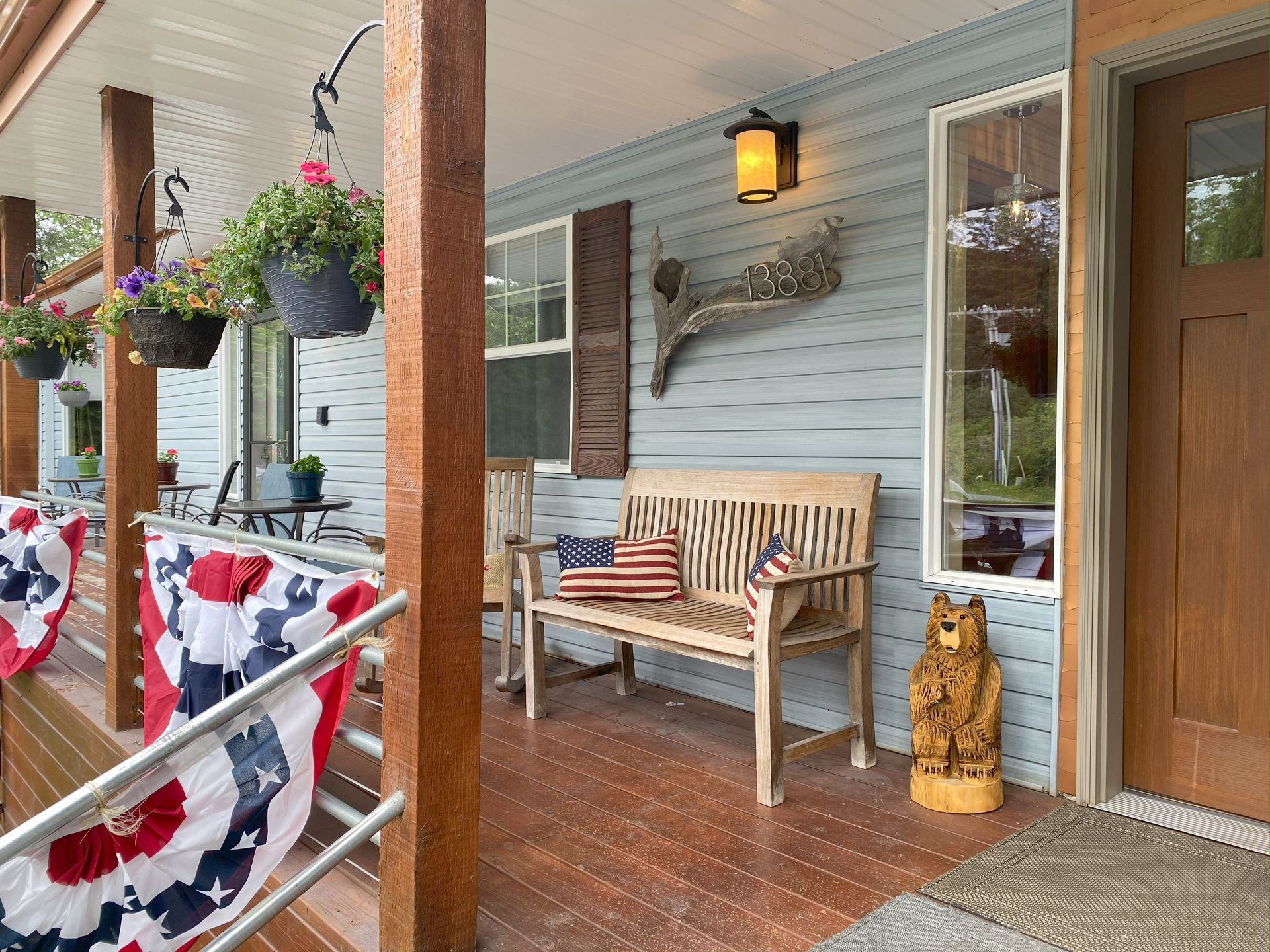 A porch with a bench and a statue of a bear.