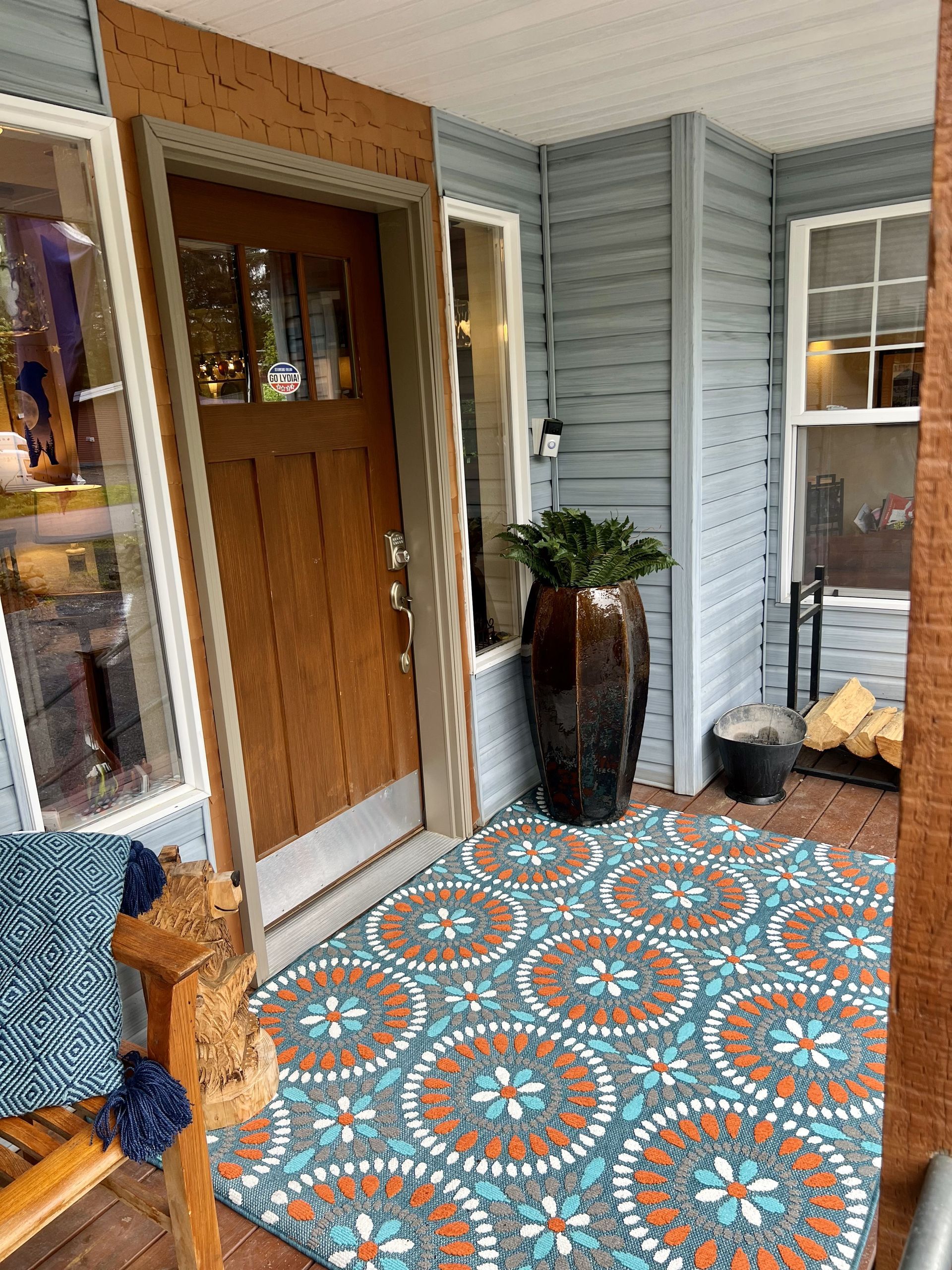 There is a rug on the porch of a house.