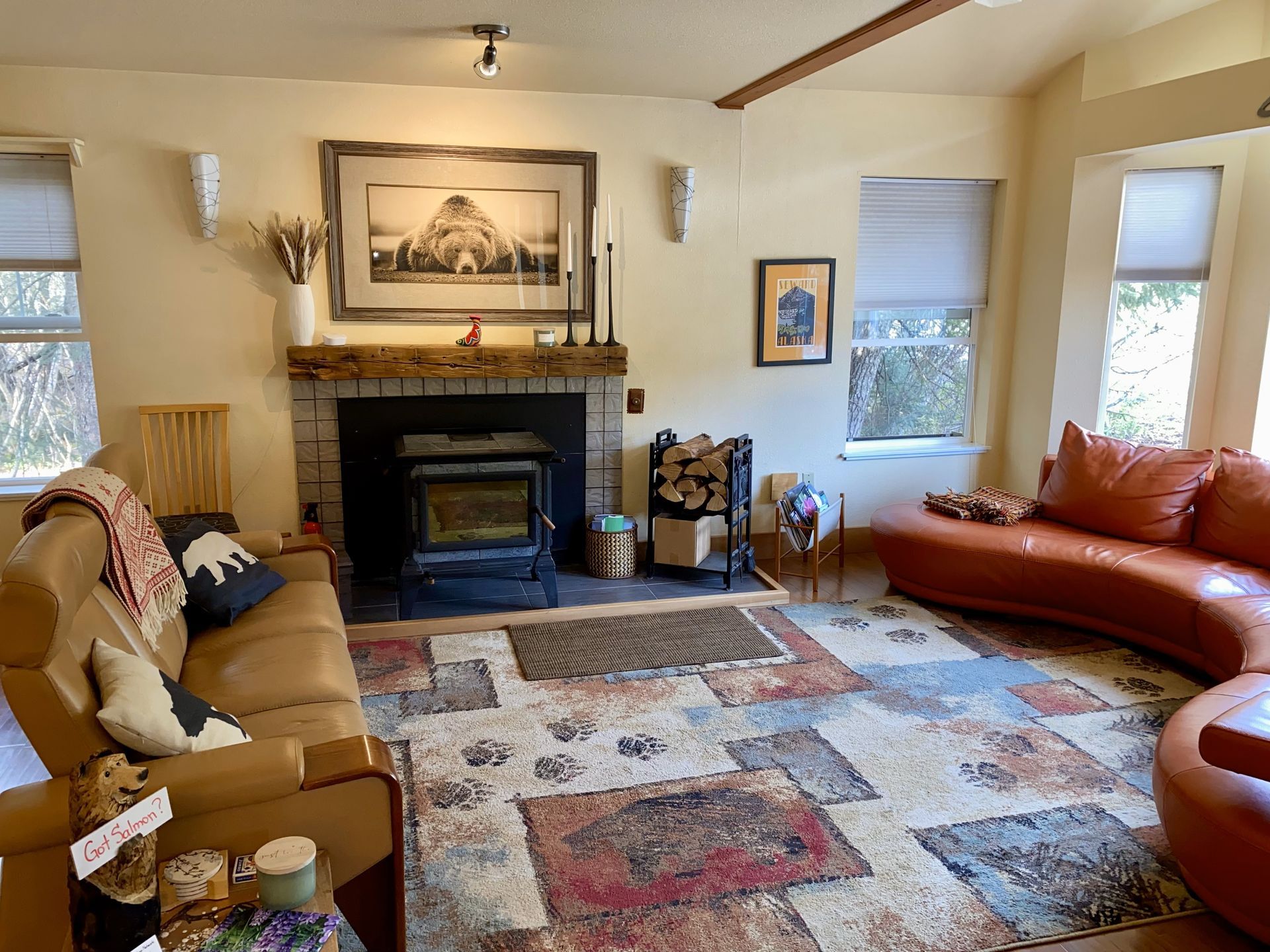 A living room with a couch , chair , fireplace and rug.
