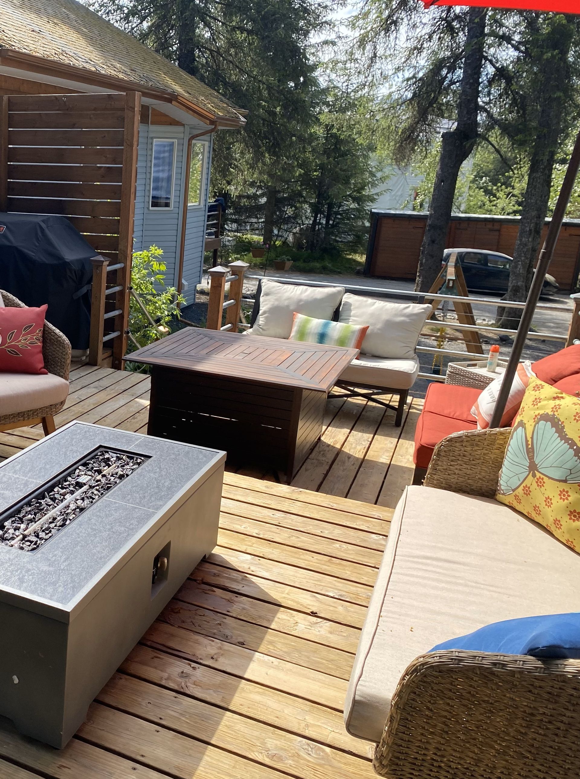 There is a fire pit on the deck with a lot of furniture on it.