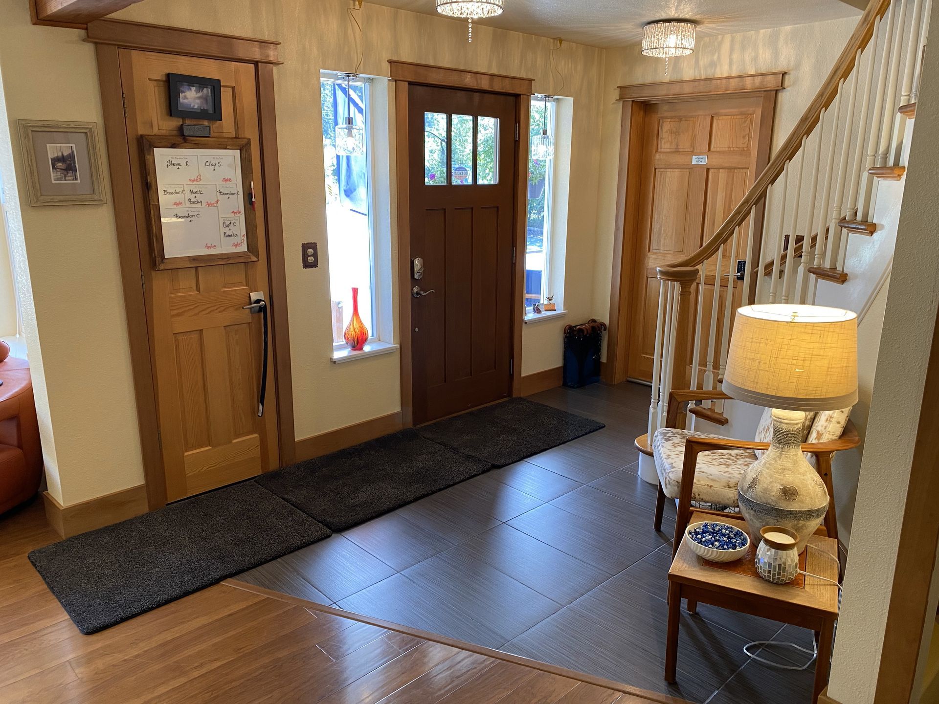 A hallway with a wooden door and stairs in a house.