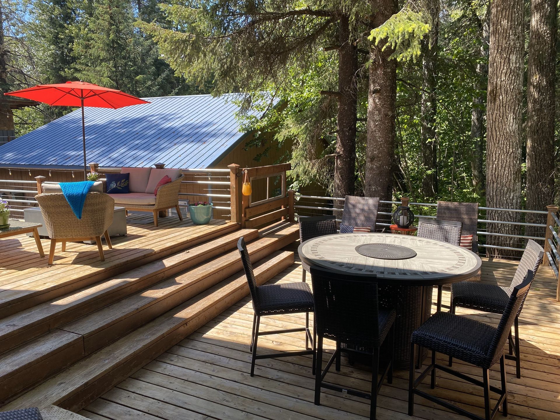 A wooden deck with a table and chairs and an umbrella.