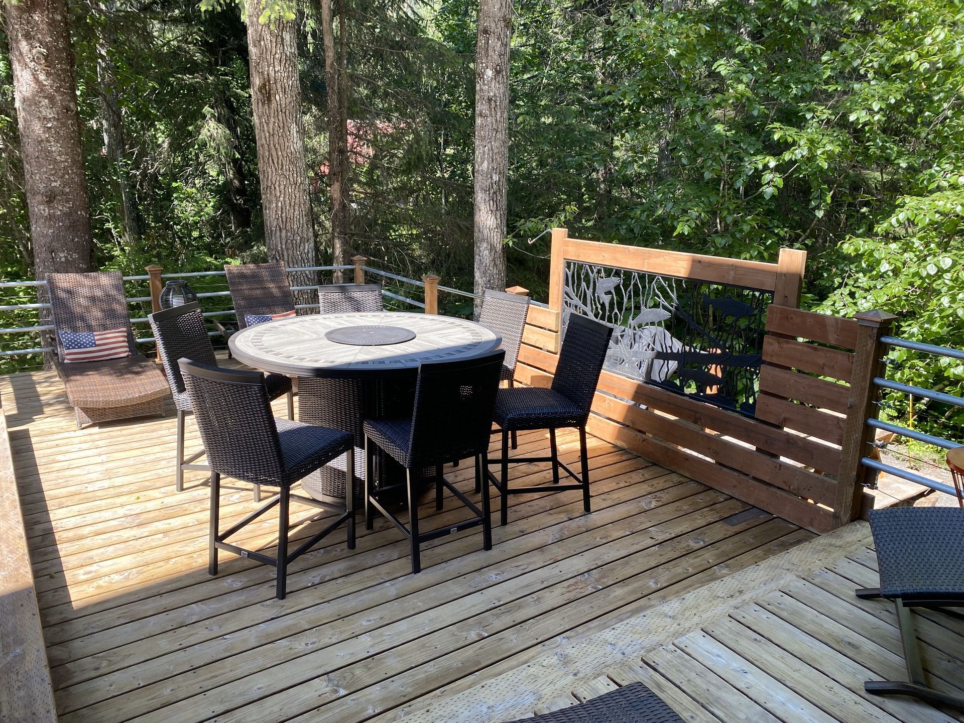 A wooden deck with a table and chairs on it.