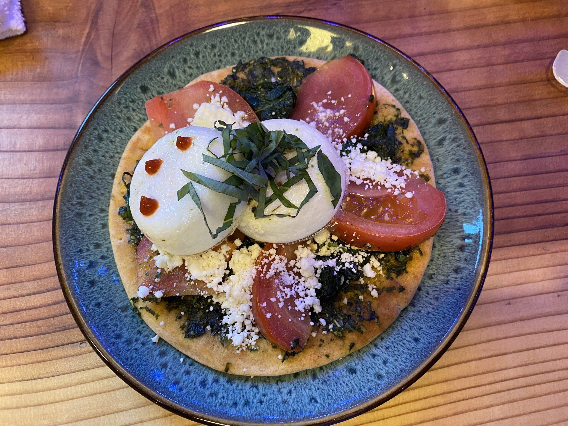 Bell In The Woods 3 course gourmet breakfast. A plate with pancake topped with burrata, tomato and basil.