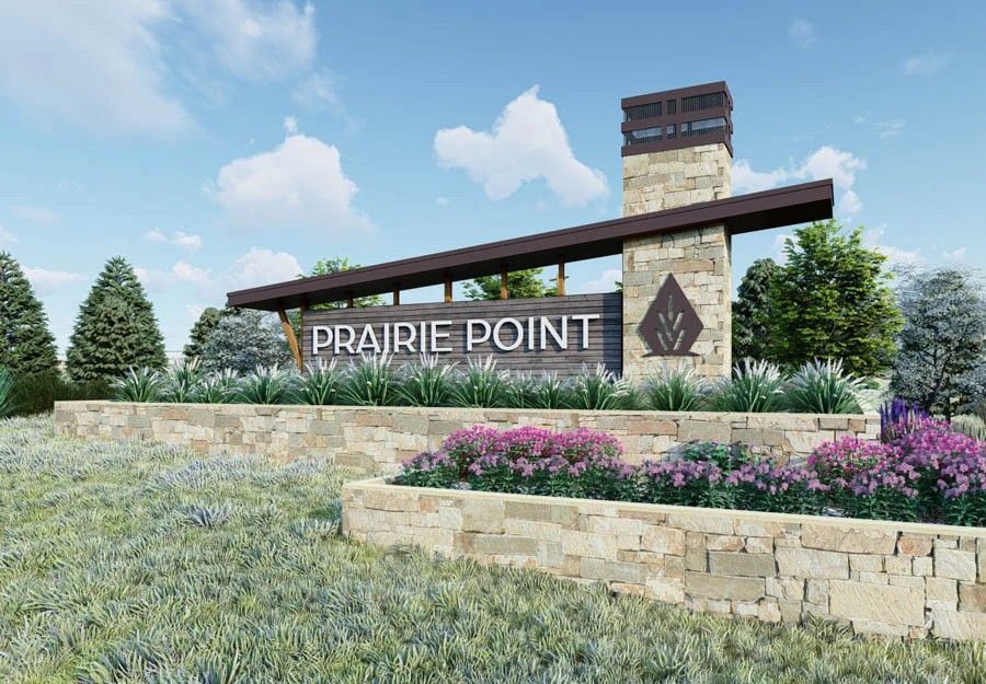 Prairie Point stone and wood entrance sign with landscaped flowers.