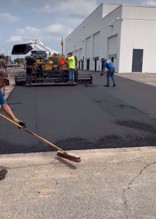 A group of construction workers are working on a road.