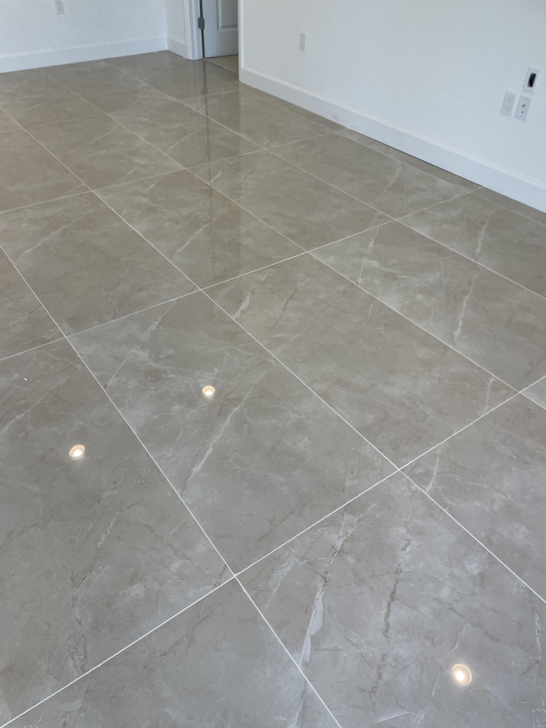 A living room with a tiled floor and white walls.