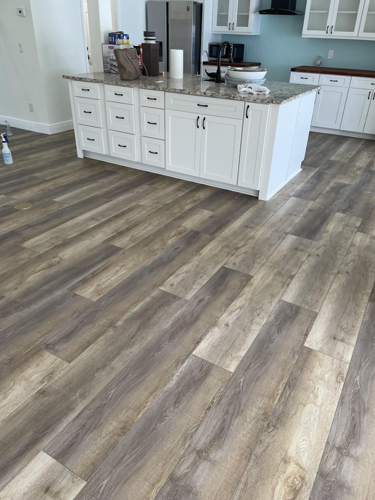 A kitchen with hardwood floors and white cabinets.