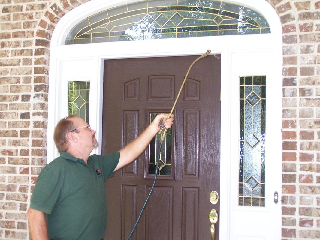 Man Exterminating A Door — Tallahassee, FL — Rock Solid Termite and Pest Control