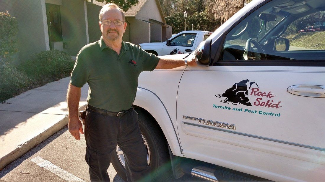 Man Beside A White Van — Tallahassee, FL — Rock Solid Termite and Pest Control