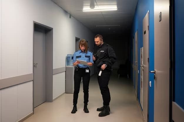 A Man And A Woman Are Standing In A Hallway Looking At A Tablet - Expert Security in Katherine, NT