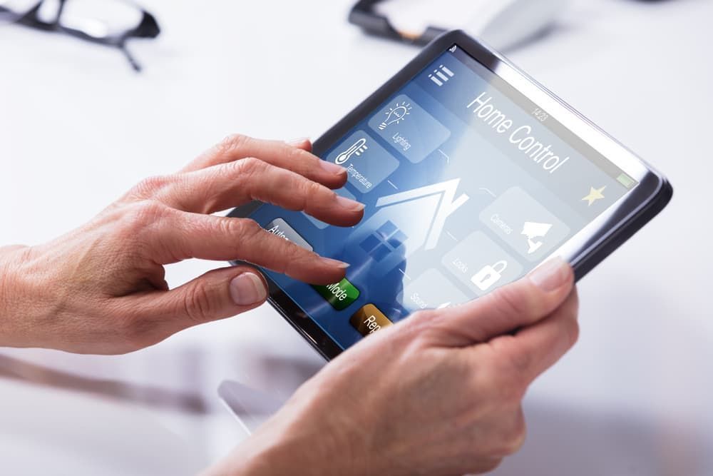 A Person Is Using A Tablet With A Home Control App On It - Comprehensive Security Services in Darwin, NT