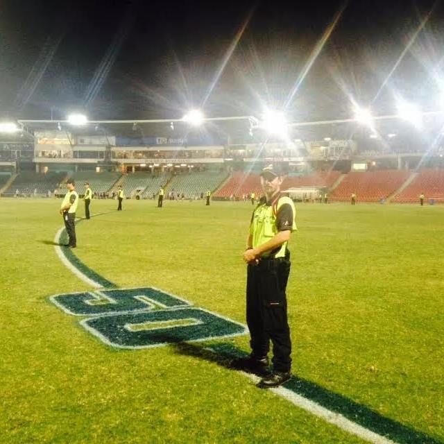 A Security Man Stands On A Football Field With The Number 50 Painted On The Grass - Expert Security in Katherine, NT