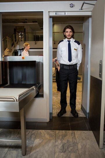 A Man In A Suit And Tie Is Standing In An Elevator - Professional Security in Darwin, NT