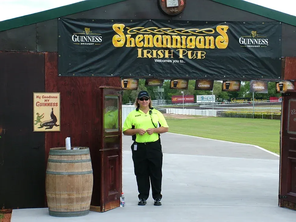 A Security Guard Is Standing Outside Of An Event Checking Bands - Comprehensive Security Services in Darwin, NT