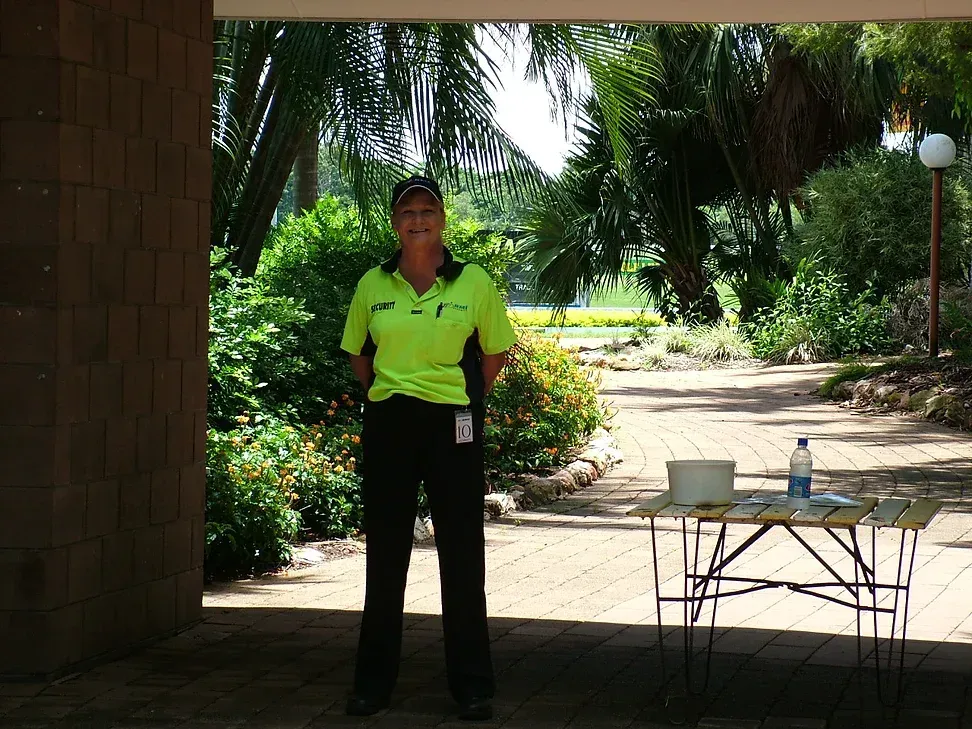 A Security Guard Standing Outside Of An Event Next To A Table - Comprehensive Security Services in Darwin, NT