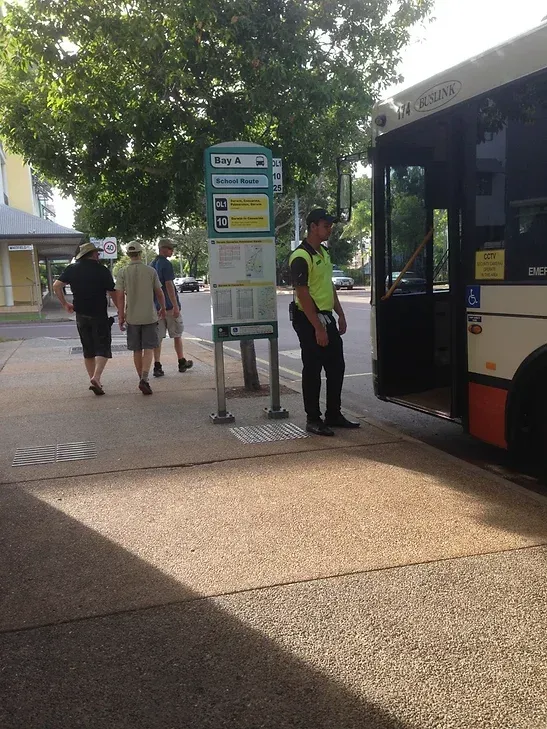 A Security Guard Standing Next To A Parked Bus - Book a Security Audits in Darwin, NT
