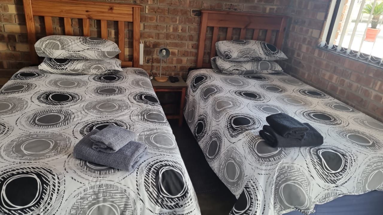 There are two beds in the room with towels on them.