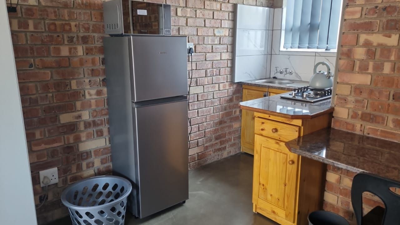 A kitchen with a refrigerator , microwave , sink , and stove.