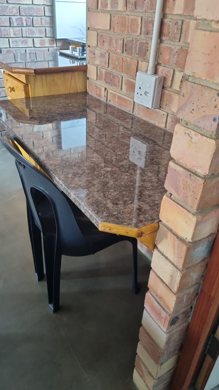 A table and chairs are sitting next to a brick wall.
